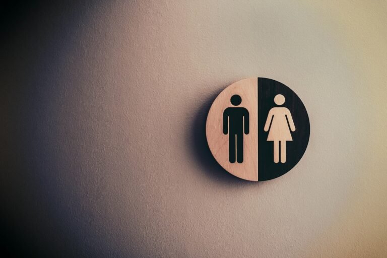 Bathroom stall sign with male and female icons, representing hidden spaces for rest during chronic pain flare-ups.