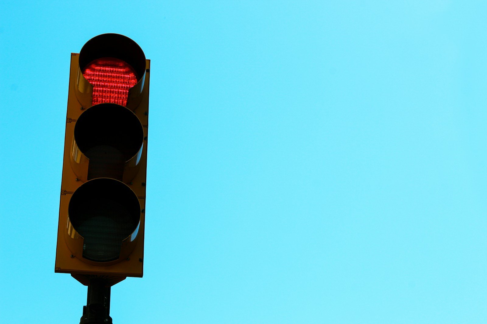 Red traffic light symbolizing a stop and reassess moment, reflecting remote work burnout and the need to pause.